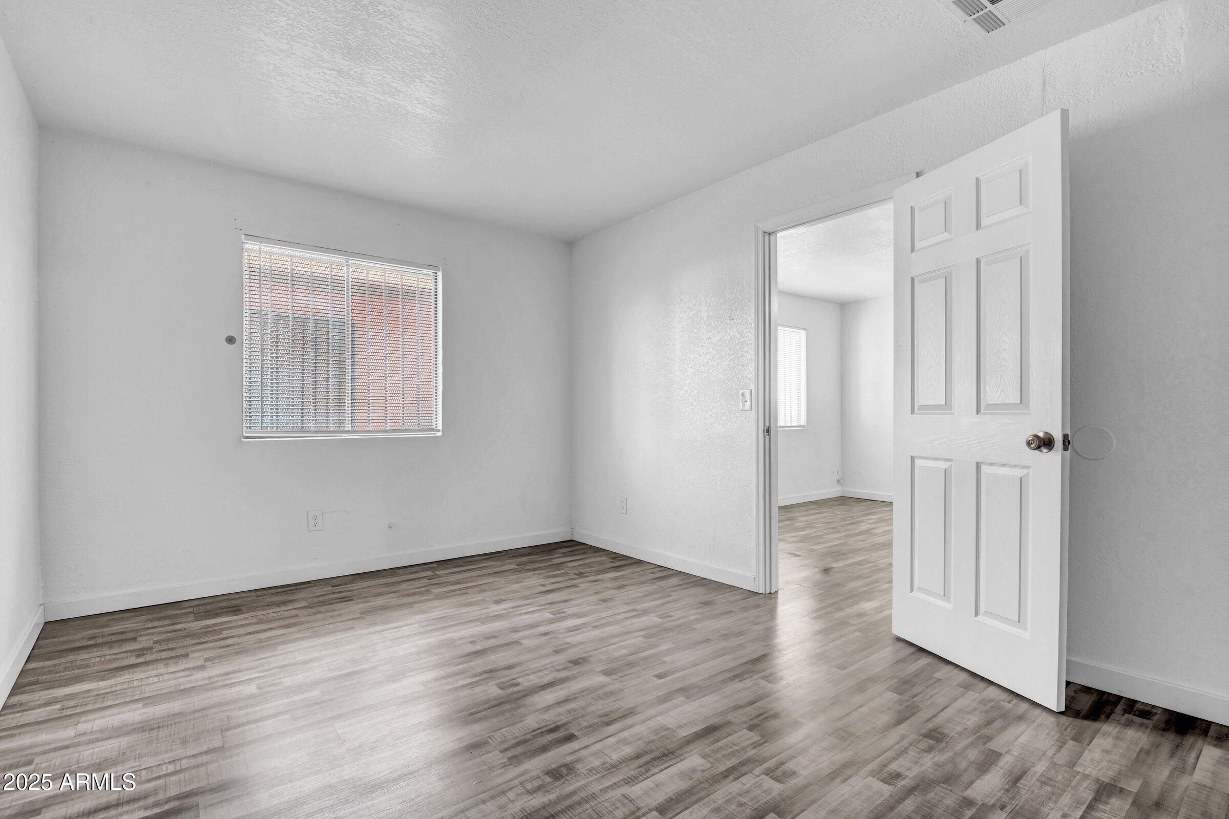 1123 West Fillmore Street Phoenix, AZ 85007 - Photo 11 of 20 a view of an empty room with wooden floor and a window