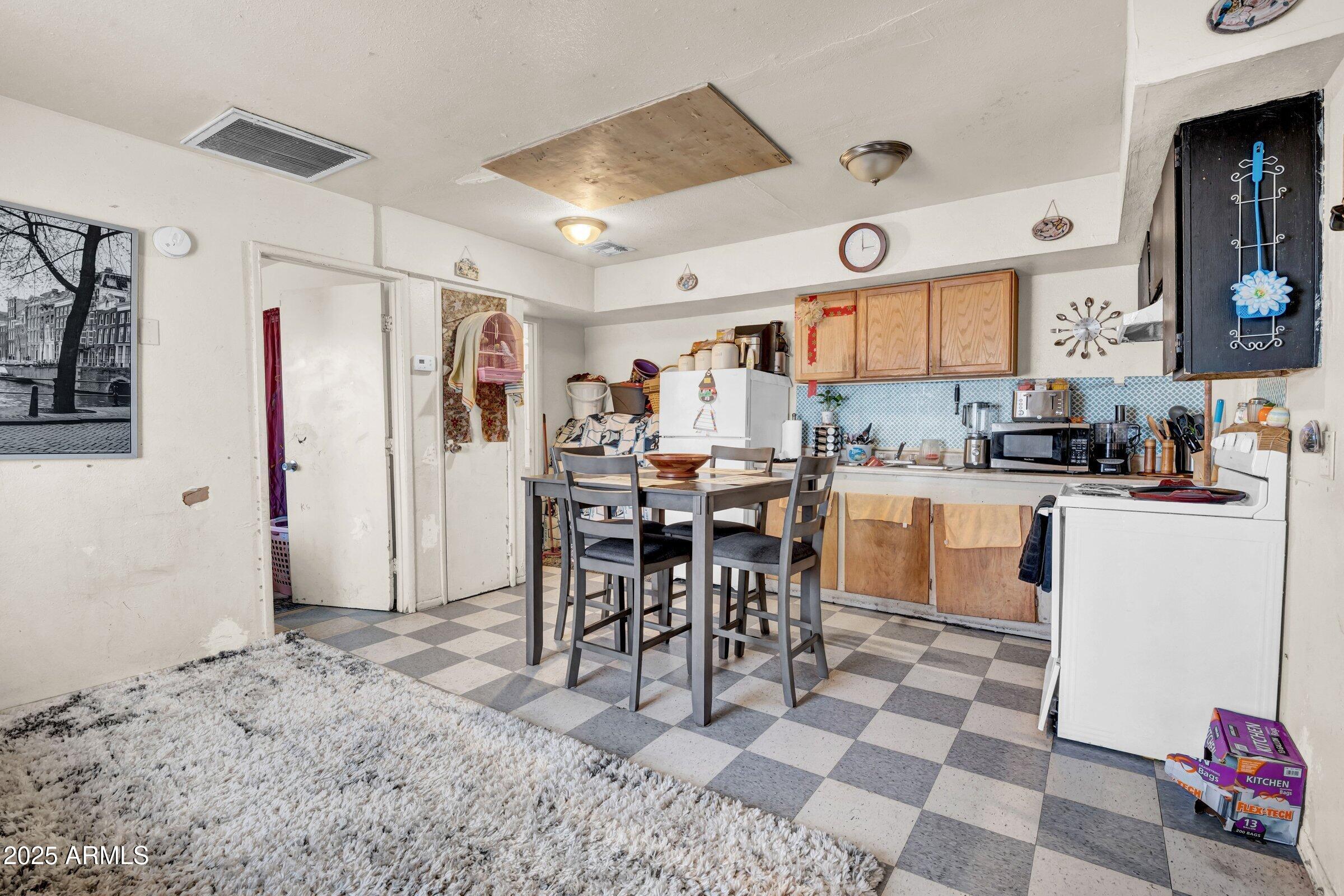 1123 West Fillmore Street Phoenix, AZ 85007 - Photo 14 of 20 a kitchen with stainless steel appliances kitchen island granite countertop a sink and a cabinets