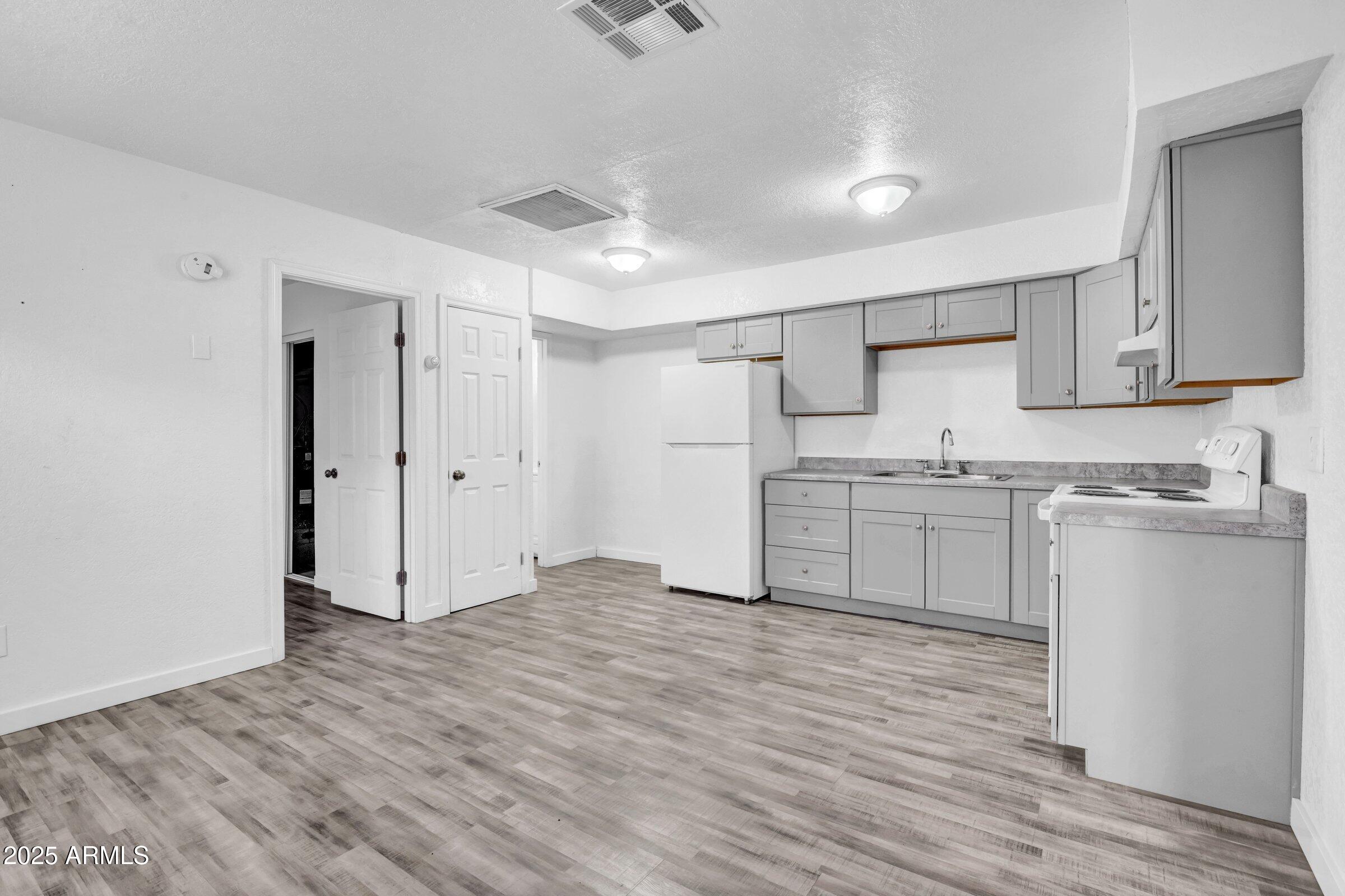 1123 West Fillmore Street Phoenix, AZ 85007 - Photo 5 of 20 a kitchen with white cabinets and white appliances