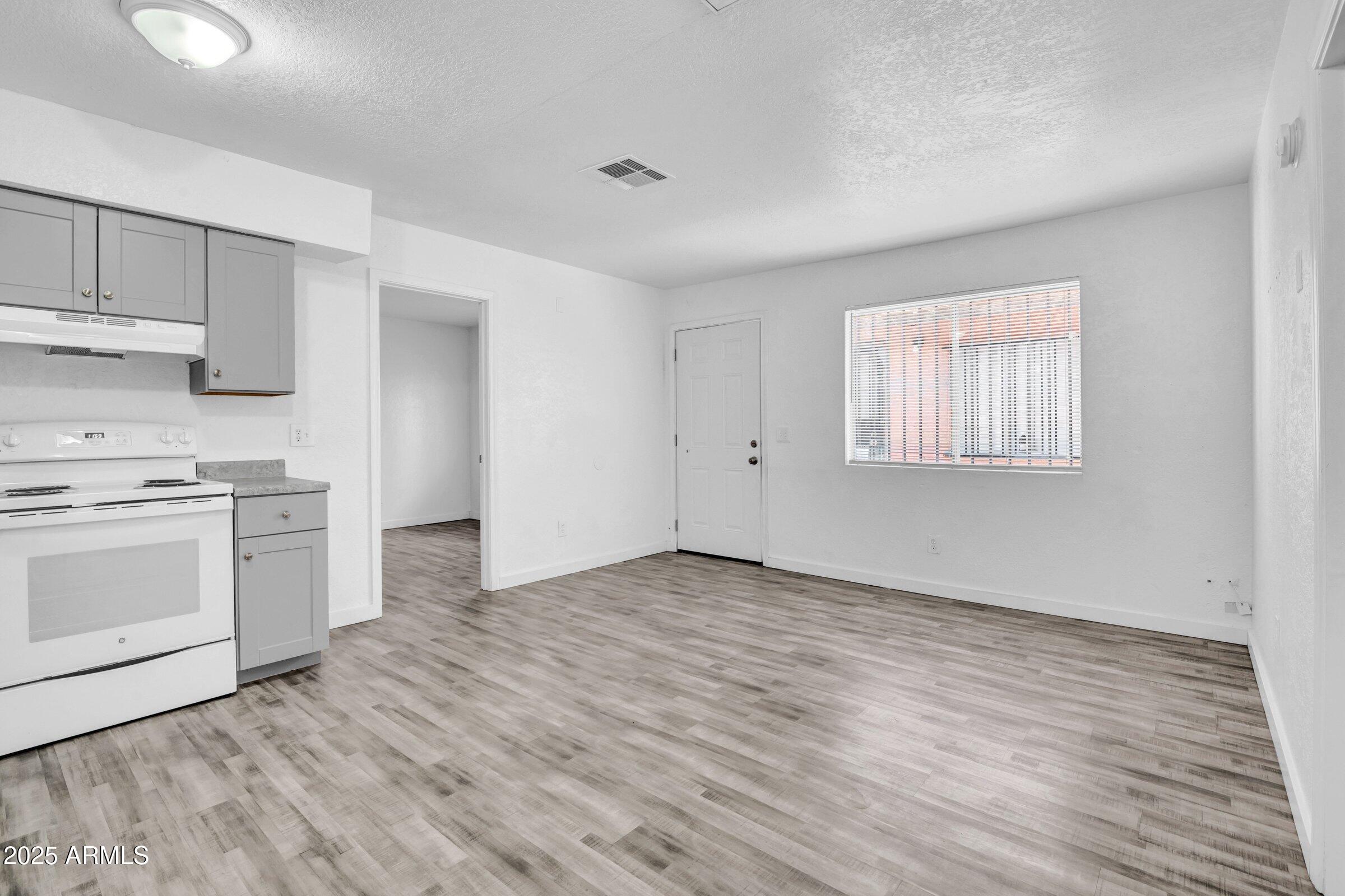 1123 West Fillmore Street Phoenix, AZ 85007 - Photo 8 of 20 a view of a kitchen with wooden floor and electronic appliances