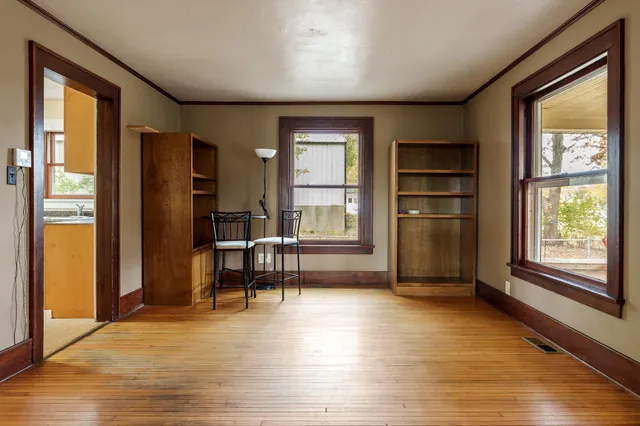 a living room with stainless steel appliances wooden floor and a window