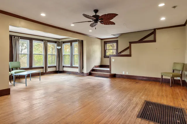 a view of empty room with wooden floor and a ceiling fan