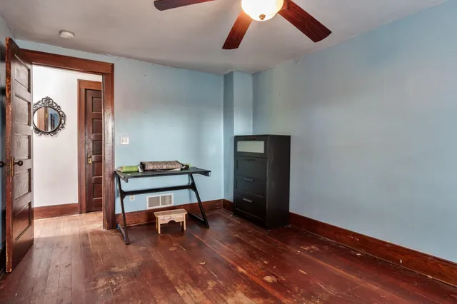 a view of an empty room with a window and kitchen view