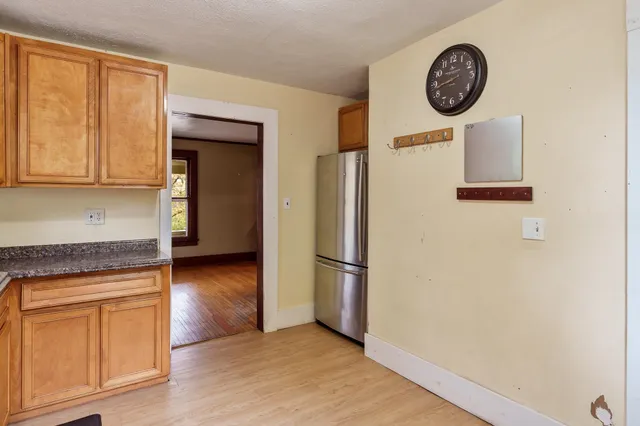 a view of a kitchen with fridge and wooden floor