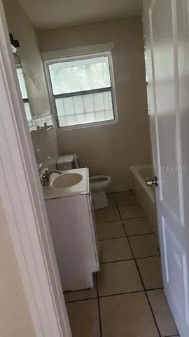 a bathroom with a sink a toilet a window and vanity