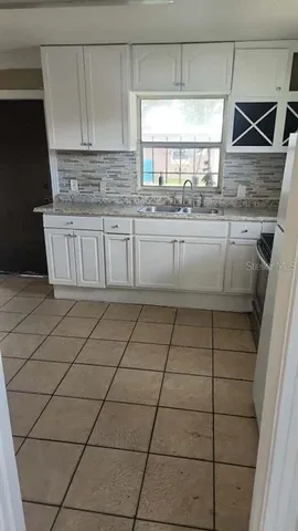 a kitchen with a sink a window and cabinets