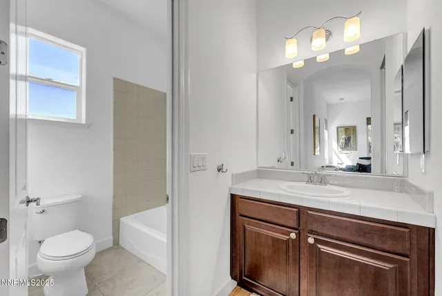 a bathroom with a sink a toilet and a large mirror