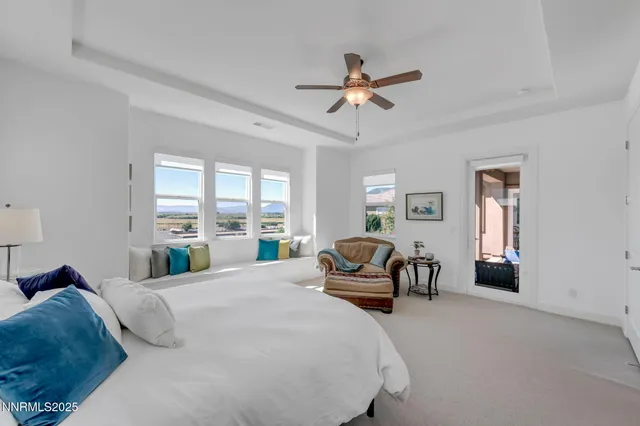 a large bedroom with a bed couch and a large window