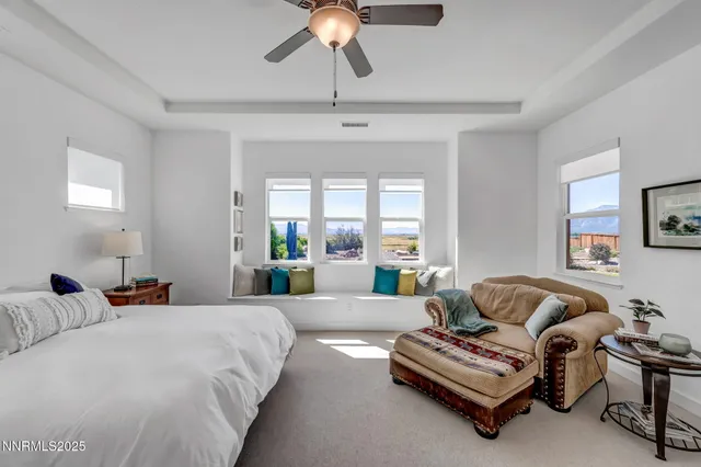 a spacious bedroom with a bed a couch and a chandelier