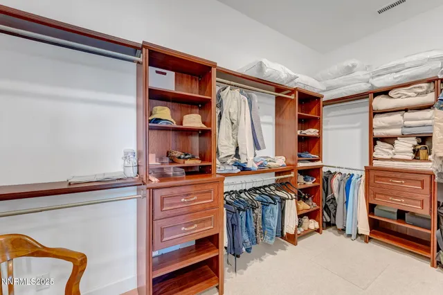 a view of walk in closet with clothes and shoes