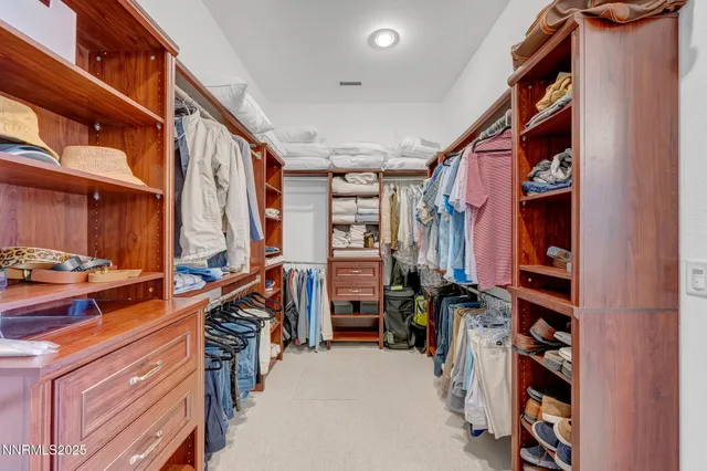 a view of walk in closet with clothes and shoes