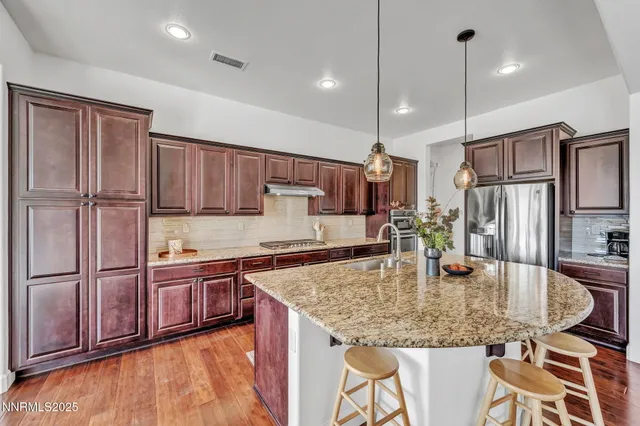 a kitchen with stainless steel appliances granite countertop a sink refrigerator and cabinets