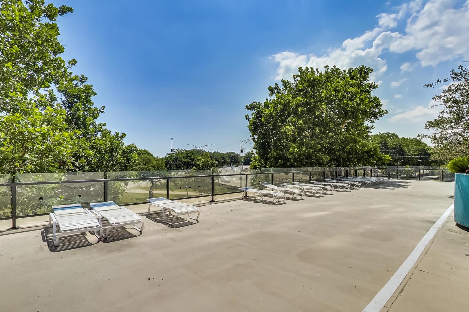 5701 North Sheridan Road, Unit 4Q Chicago, IL 60660 - Photo 21 of 23 a view of a lake with a table and chairs under an umbrella