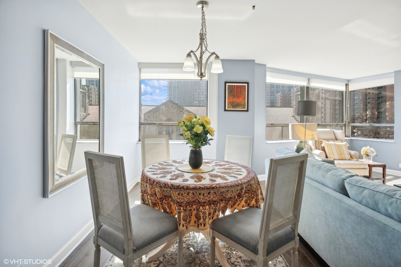 5701 North Sheridan Road, Unit 4Q Chicago, IL 60660 - Photo 8 of 23 a dining room with furniture a chandelier and wooden floor