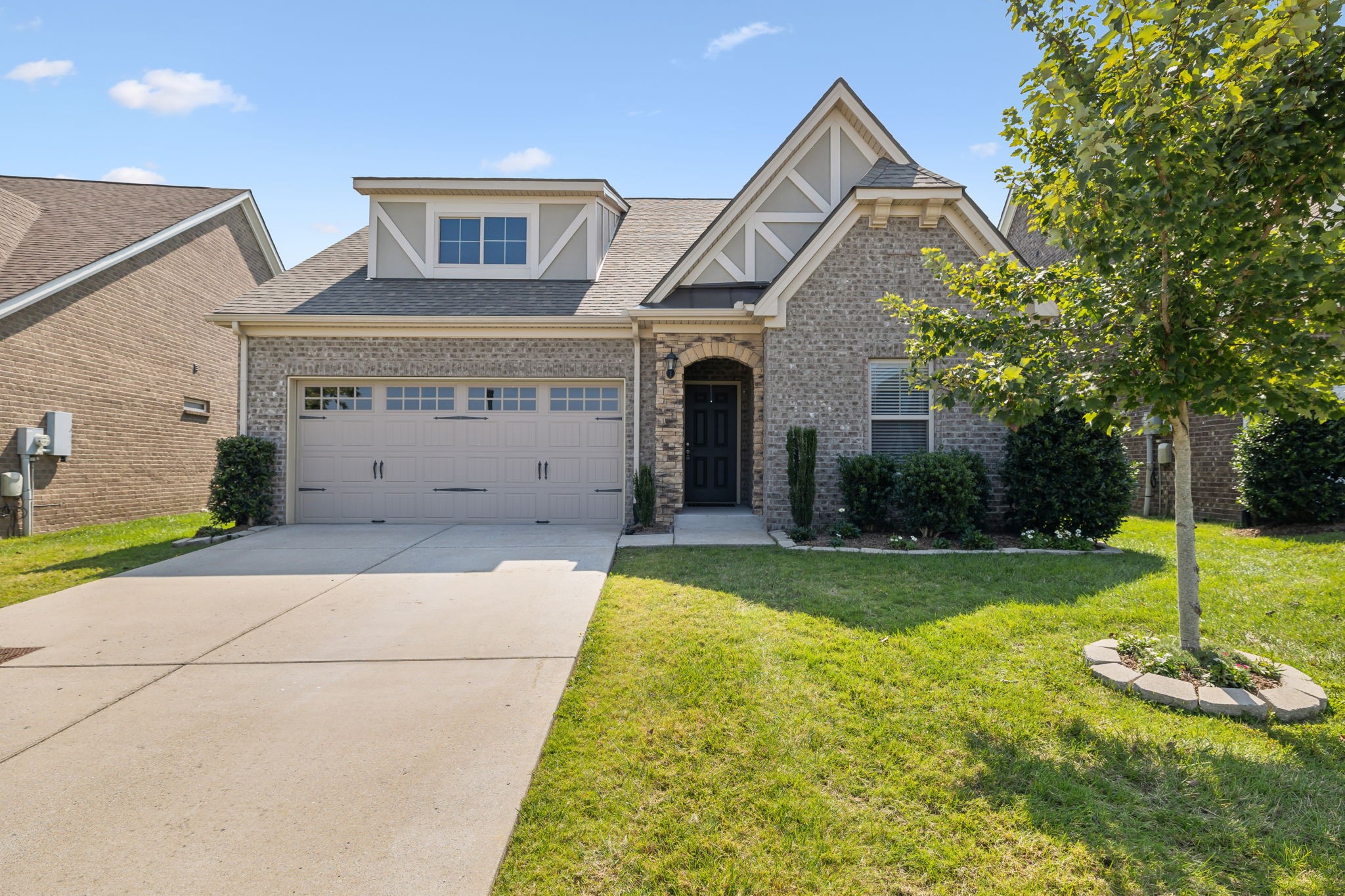 a front view of a house with a yard garage and trees