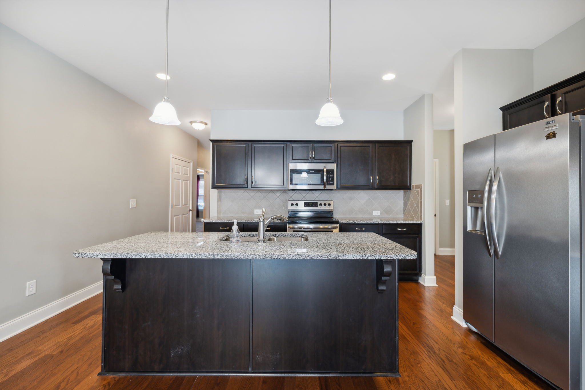 1229 Mayflower Way Lebanon, TN 37087 - Photo 11 of 42 a large kitchen with stainless steel appliances granite countertop a sink a stove a refrigerator and island with wooden floor