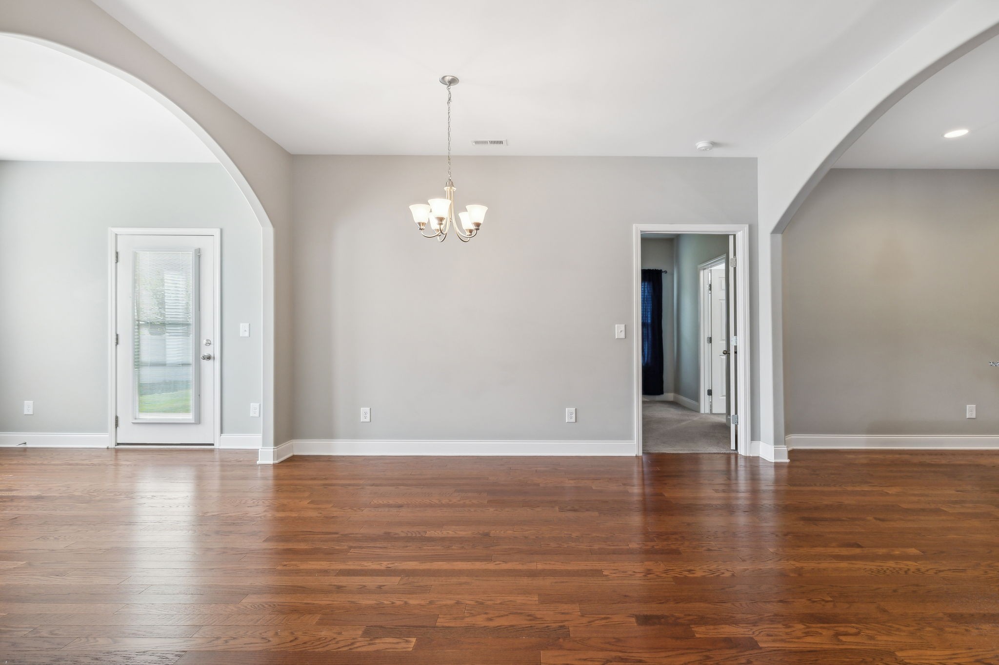 1229 Mayflower Way Lebanon, TN 37087 - Photo 17 of 42 an empty room with wooden floor chandelier and windows