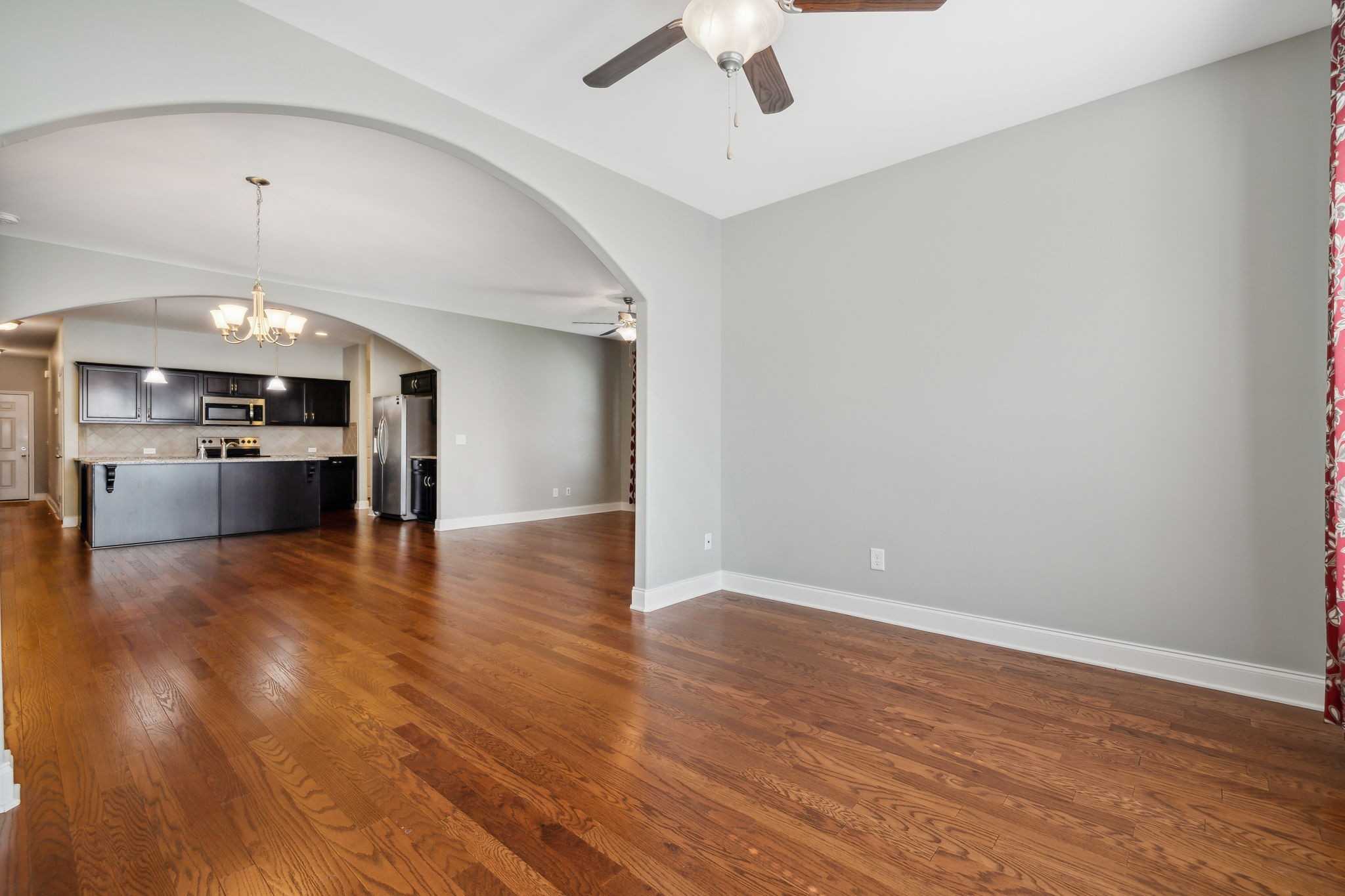 1229 Mayflower Way Lebanon, TN 37087 - Photo 24 of 42 an empty room with wooden floor kitchen view and a chandelier