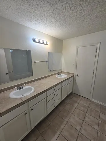 a spacious bathroom with a double vanity sink and mirror