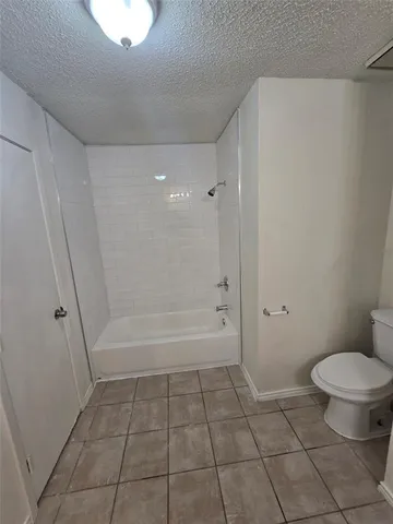 a bathroom with a granite countertop bathtub and toilet