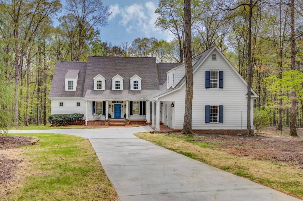 a view of a house with a yard and large tree
