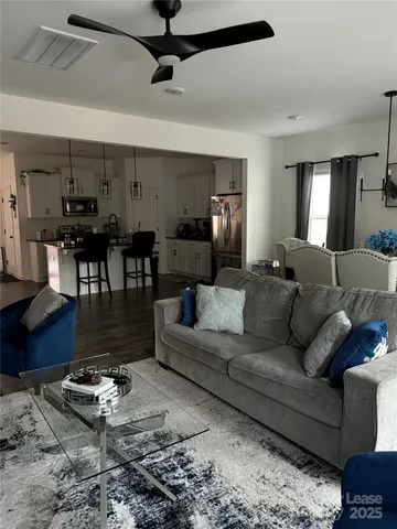 a living room with furniture and a dining table with rug