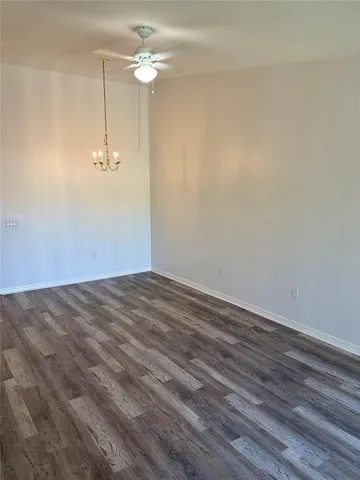 an empty room with a chandelier fan