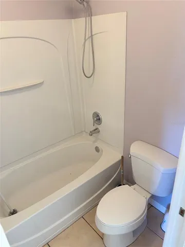 a white toilet and tub sitting next to a bathroom sink