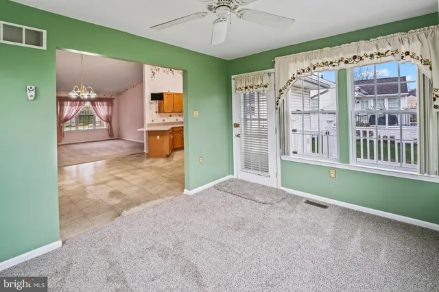 an empty room with windows and fan