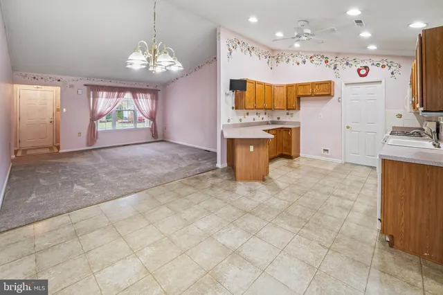 a view of a kitchen with granite countertop a sink cabinets and window
