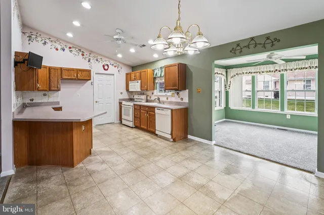 a large kitchen with stainless steel appliances granite countertop a stove oven and a refrigerator