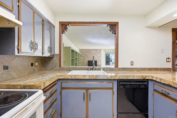 a kitchen with granite countertop a sink and a stove