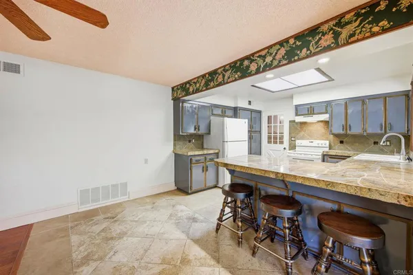 a kitchen with stainless steel appliances granite countertop a sink a stove and a refrigerator
