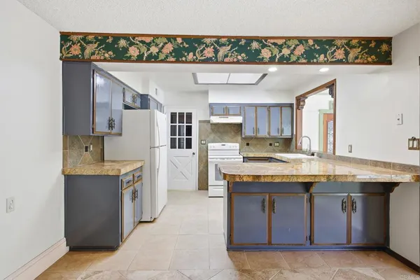 a kitchen with kitchen island a sink counter top space and appliances
