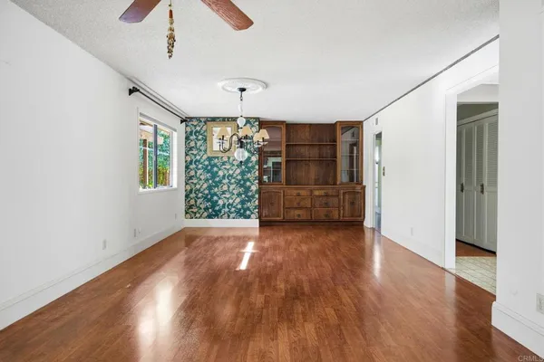 a view of empty room with wooden floor and entryway