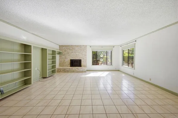 a view of an empty room with a fireplace and a window