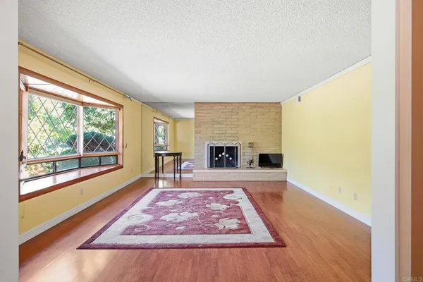 a living room with a rug floor to ceiling window and a fireplace
