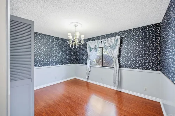 a view of a room with wooden floor and a ceiling fan