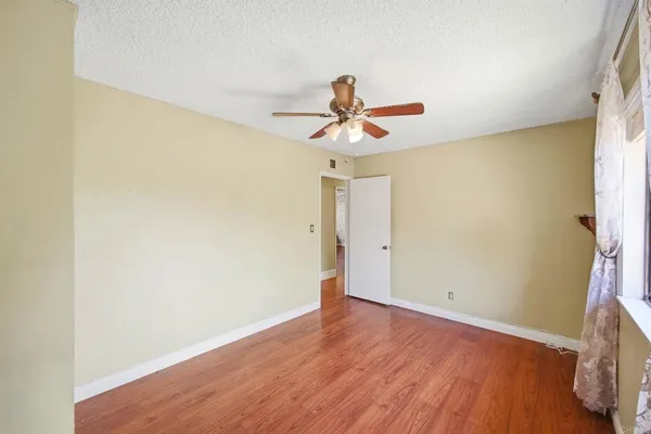 a view of a hallway with wooden floor and large windows