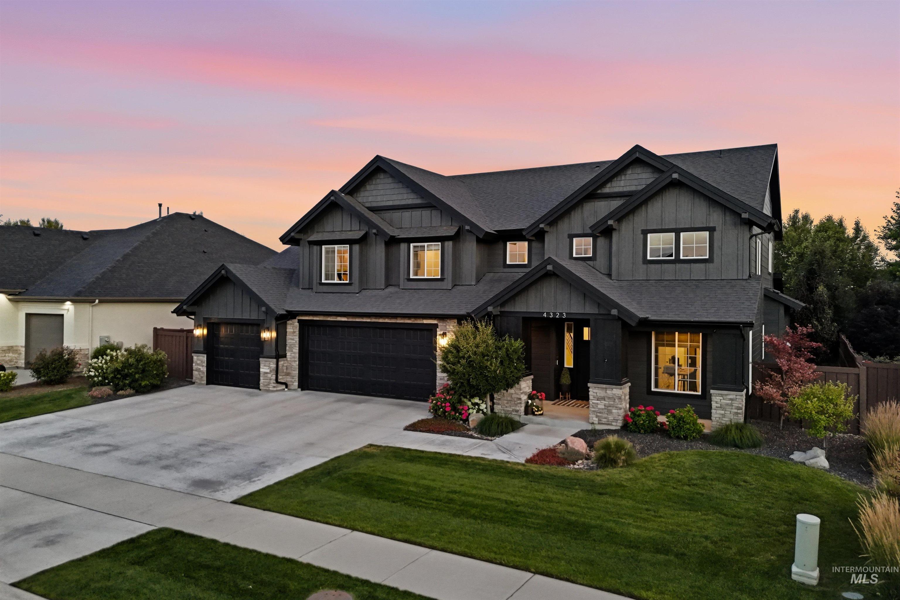 4323 West Ladle Rpds Drive Meridian, ID 83646 - Photo 2 of 49 Contemporary two-story exterior featuring dark siding, stone accents, and a multi-gabled roofline