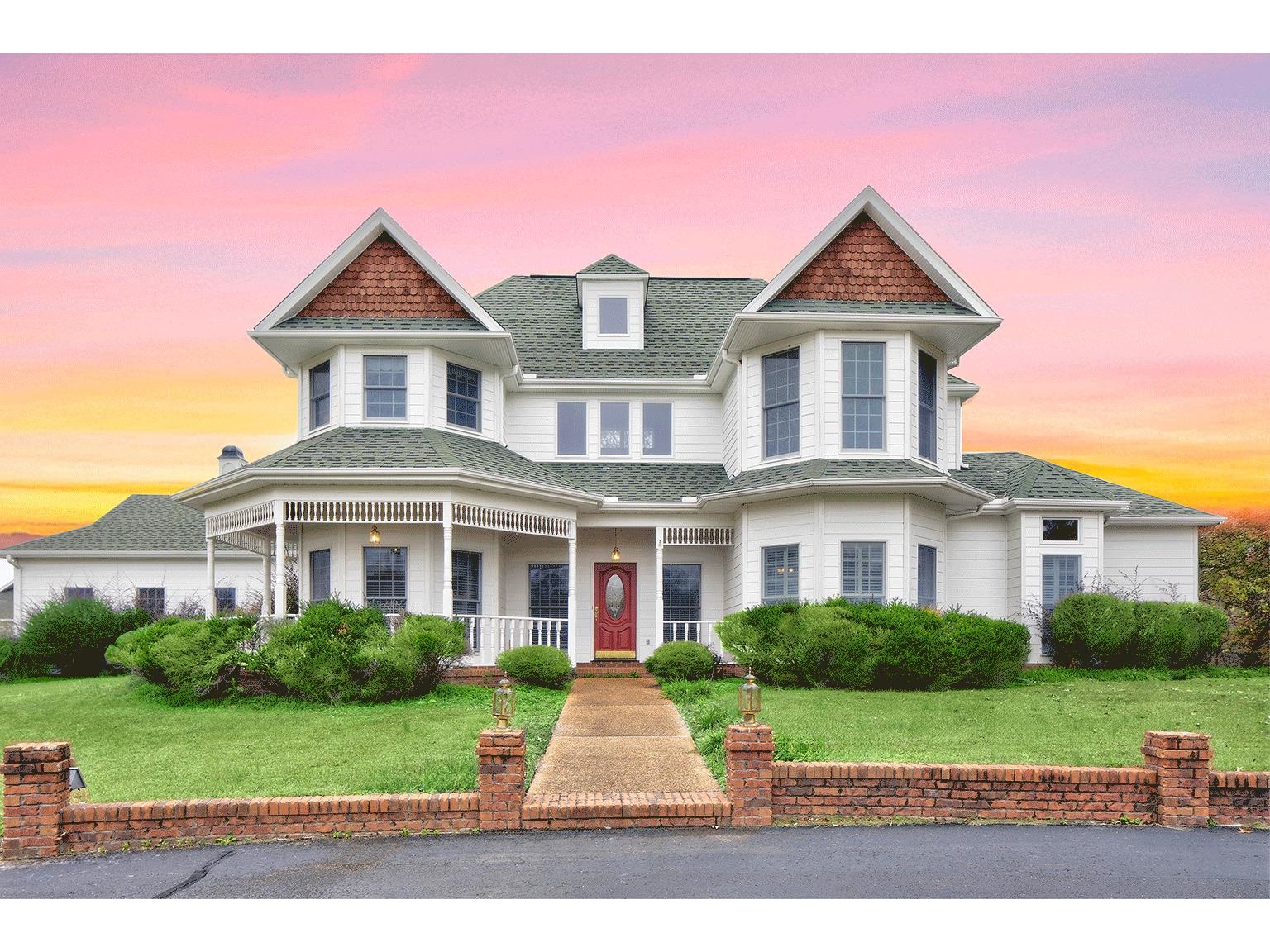 Victorian home featuring covered porch and a yard