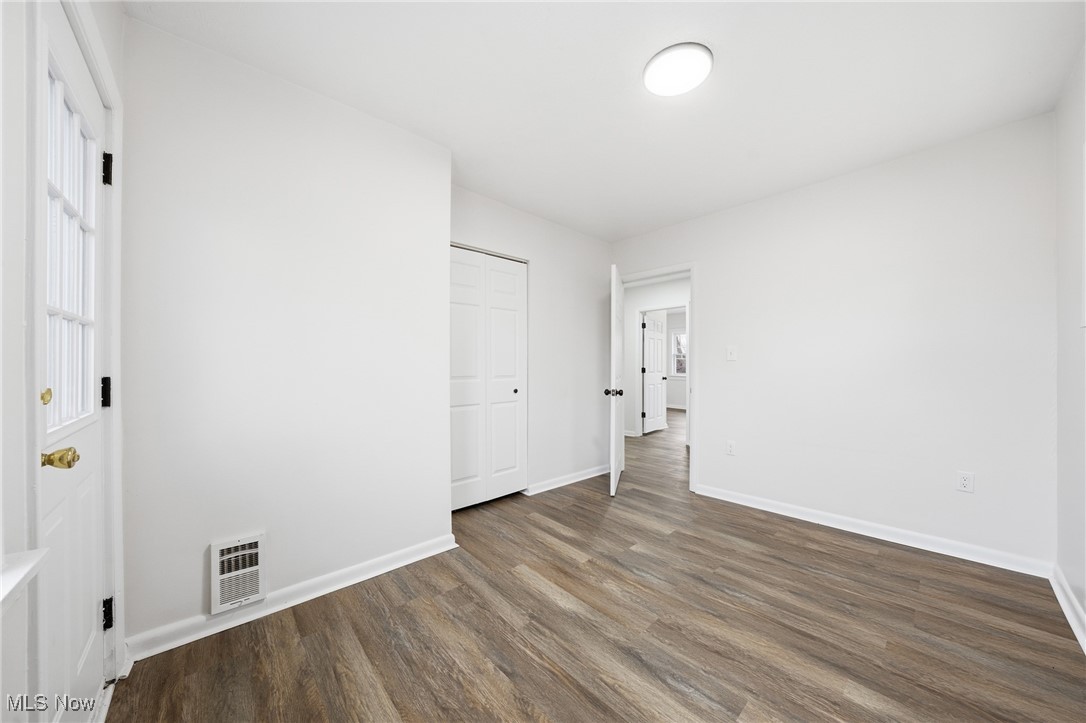 7911 Snow Road Parma, OH 44129 - Photo 22 of 44 Unfurnished bedroom with dark wood-style floors and a closet