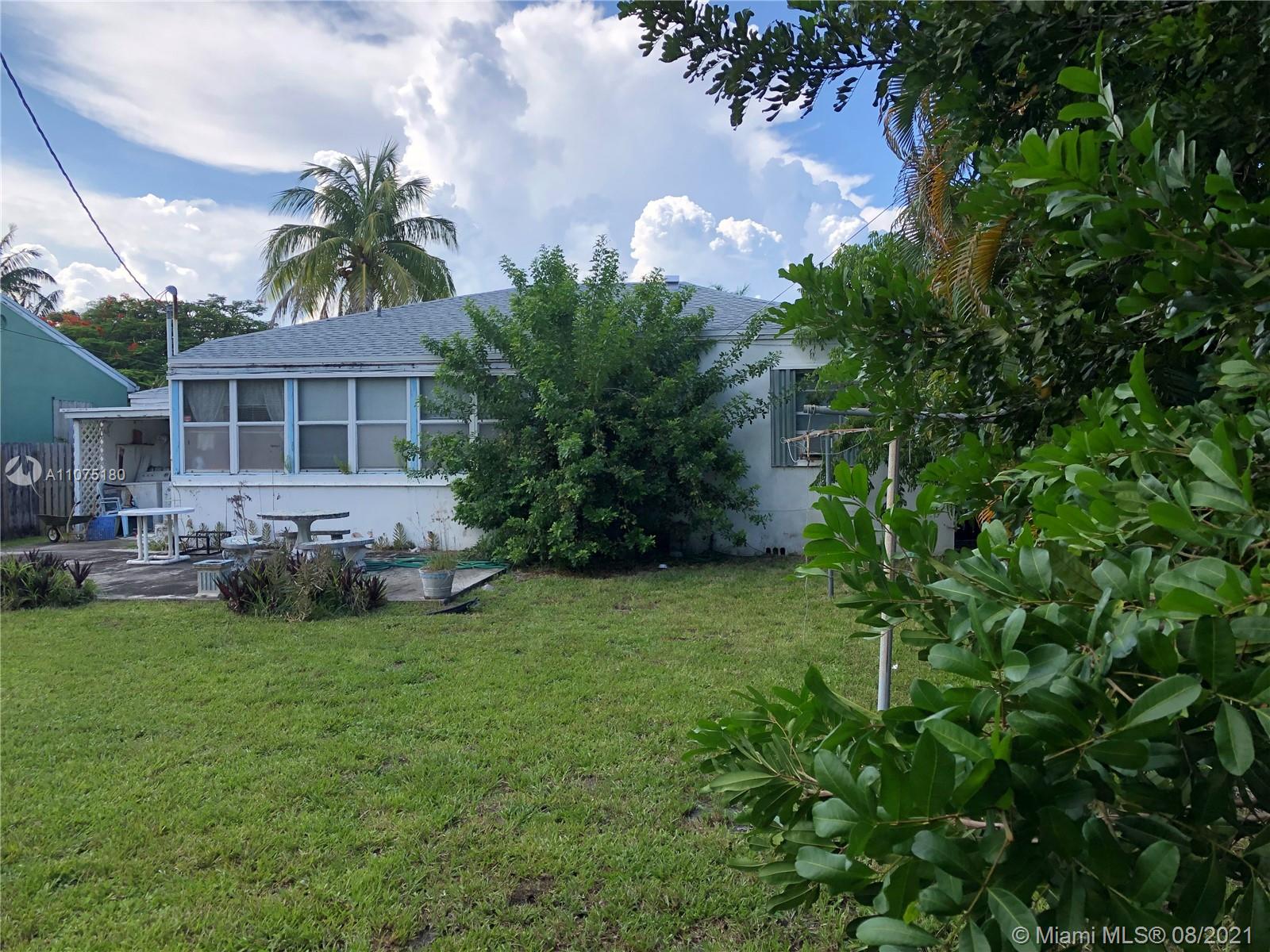 1504 Funston Street Hollywood, FL 33020 - Photo 3 of 10 a view of a backyard with table and chairs potted plants and large tree