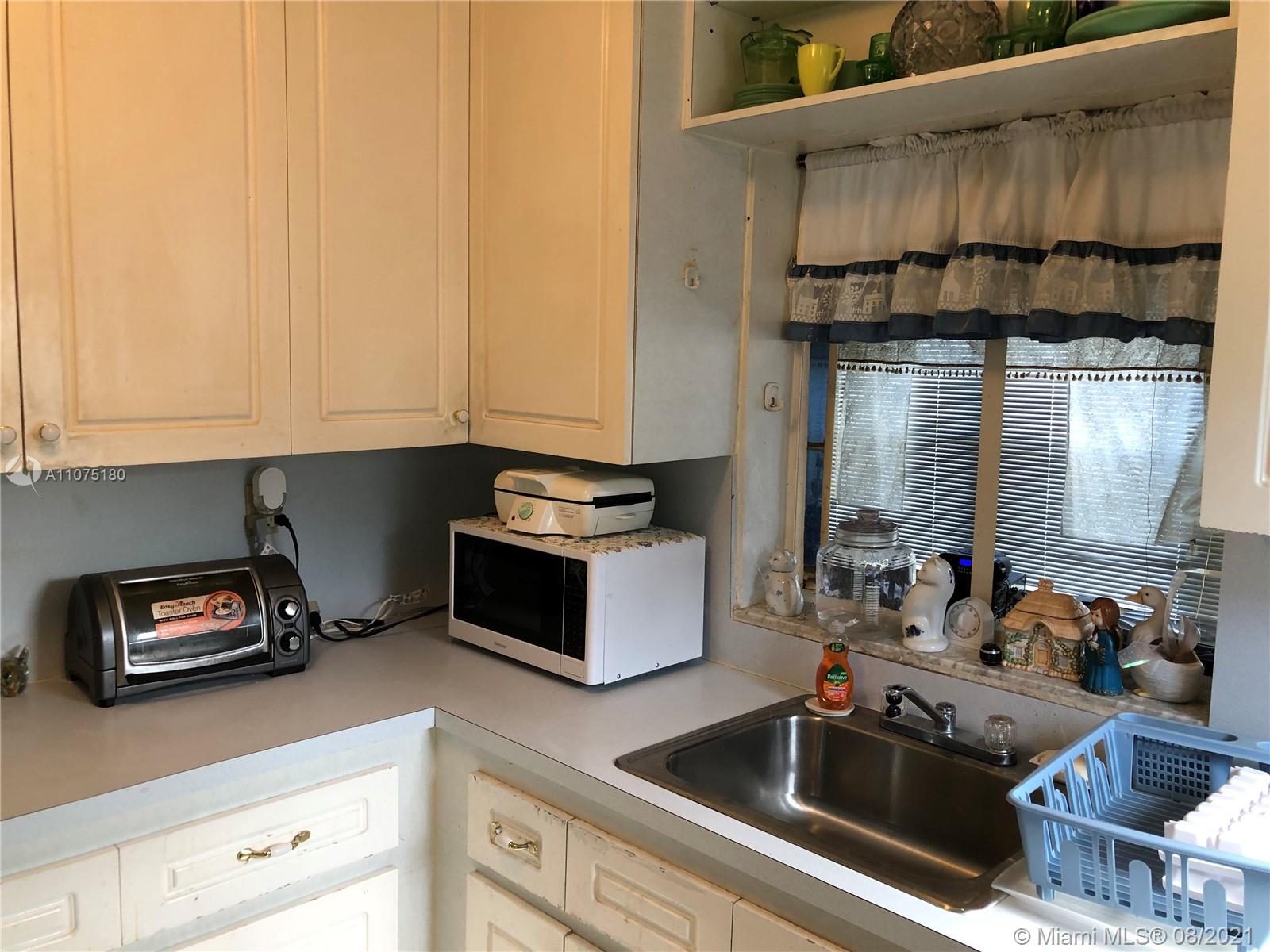 1504 Funston Street Hollywood, FL 33020 - Photo 6 of 10 a kitchen with granite countertop a sink a stove and cabinets