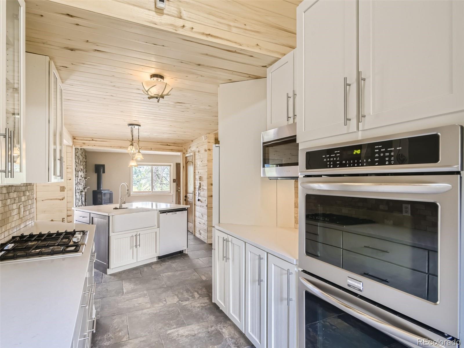 598 Rising Sun Road Bailey, CO 80421 - Photo 10 of 28 a kitchen with a stove and white cabinets