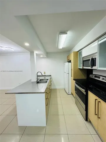 a kitchen with stainless steel appliances granite countertop a sink and a stove top oven with wooden floor