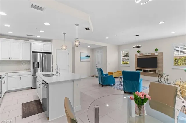 a living room with furniture a flat screen tv and kitchen view