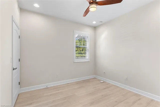 an empty room with a window and wooden floor