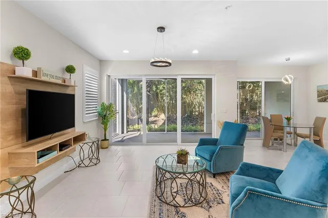 a living room with furniture a flat screen tv and a large window