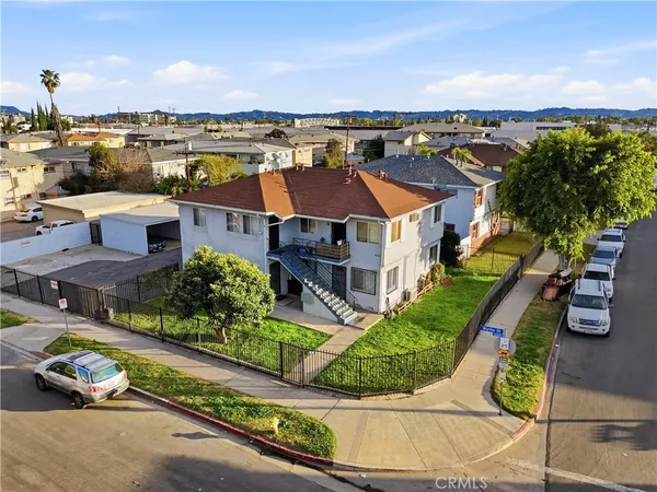 an aerial view of multiple houses with a yard